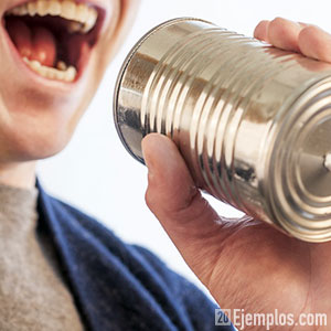 Persona hablando por un teléfono de lata con hilo